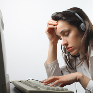 someone sitting at a desk with a phone, looking bored